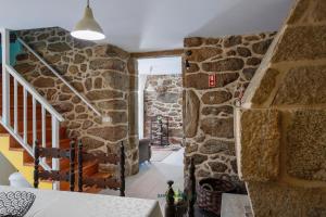 a stone wall in a house with a staircase at Casa Cabreiros de Baixo in Melgaço