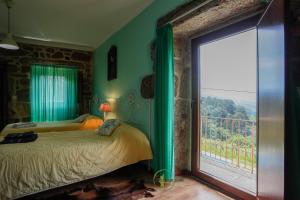 a bedroom with a bed and a large window at Casa Cabreiros de Baixo in Melgaço