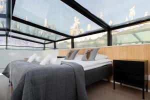 a bedroom with two beds in front of a large window at Aurora Paradise Levi Iglu in Levi