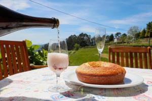 a bottle of wine being poured into a glass next to a cake at Casa Cabreiros de Baixo in Melgaço
