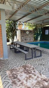 a picnic table on a patio next to a swimming pool at Casa Completa in Rancho San Pedro