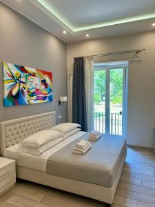a bedroom with a bed with a painting on the wall at ROYAL GARDENS in Caserta