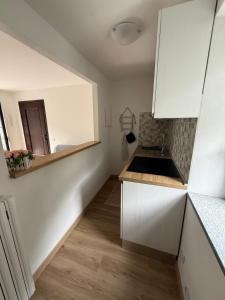 a small kitchen with white cabinets and a sink at Casa Aurelia in Pella