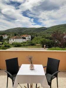 a table and two chairs on a balcony with a view at Apartments Nela in Jelsa