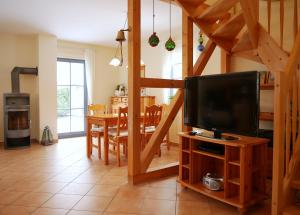 a living room with a tv and a dining room with a table at Hagebutte in Am Schwarzen Busch