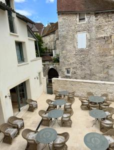 a patio with tables and chairs in front of a building at Logis Hôtel Maison Turenne in Martel
