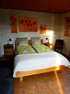 a bedroom with a bed and two tables and two lamps at Appartement La Coudraie in Blonay