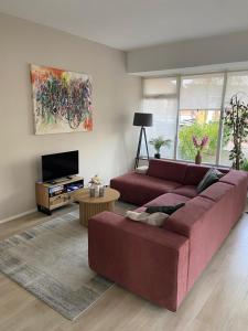 a living room with a red couch and a tv at City Apartments in Leeuwarden