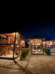 a couple of buildings on the beach at night at Pousada Villa Velejo in Grossos