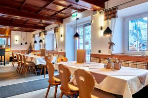 a restaurant with tables and chairs in a room at Berghaus Stuben Arlberg mit Sauna Panoramablick und Nähe zur Piste in Stuben am Arlberg