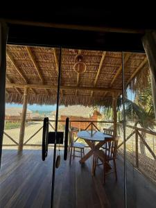 a table and chairs on the deck of a hut at Pousada Villa Velejo in Grossos