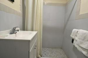 a white bathroom with a sink and a shower at Cross City Motel by Hotel O US 19 in Cross City