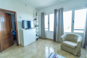 a living room with a chair and a television at Edificio Prieto VIV 2A in Puerto del Rosario