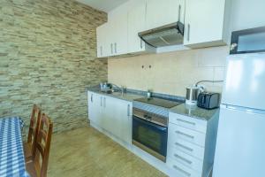 a kitchen with white cabinets and a refrigerator at Edificio Prieto VIV 2A in Puerto del Rosario