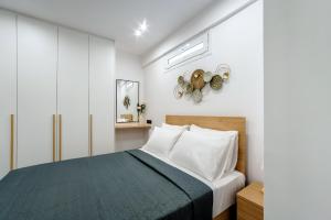a bedroom with a bed with white pillows and a window at Eirini & Nicol Studios by Cretanhouses in Thérissos