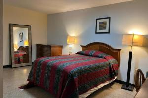 a bedroom with a bed and two lamps and a mirror at Cross City Motel by Hotel O US 19 in Cross City