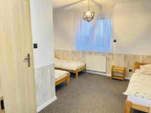 a room with two beds and a window at M&M Marzeniowo in Chlebowo