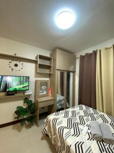 a bedroom with a bed and a flat screen tv at ARC Hive Staycation in Suba +12 photos