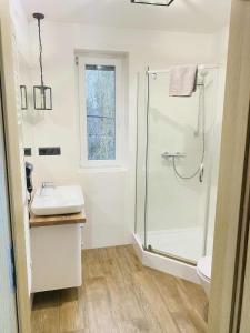 a white bathroom with a shower and a sink at M&M Marzeniowo in Chlebowo