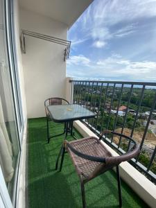 a balcony with two chairs and a table and a view at ARC Hive Staycation in Suba