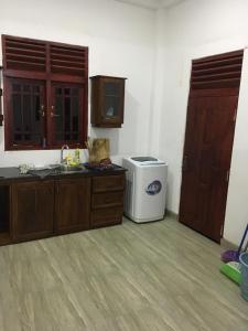 a kitchen with a sink and a trash can at Ranga's house in Minuwangoda