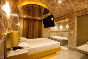 a bedroom with a bed and a bathroom with a tub at Motel Classe A (Adult Only) in São Paulo