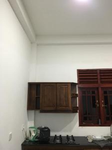 a kitchen with wooden cabinets and a counter top at Ranga's house in Minuwangoda +2 photos