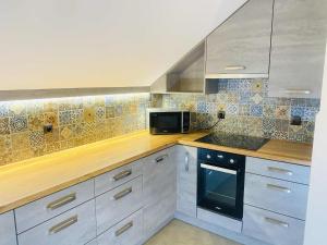 a kitchen with white cabinets and a black microwave at M&M Marzeniowo in Chlebowo