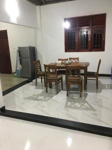 a dining room with a table and chairs and a refrigerator at Ranga's house in Minuwangoda