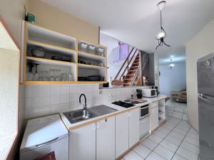 a kitchen with white cabinets and a sink at Le Céleste - Maison de vacances familiale in Châtel-Guyon
