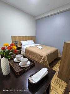 a hotel room with a bed and a table with a tray of food at Hotel Ayacucho in San Antonio