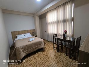 a bedroom with a bed and a desk and a table at Hotel Ayacucho in San Antonio +3 photos
