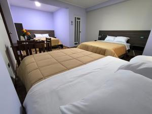 a hotel room with two beds and a table at Hotel Ayacucho in San Antonio