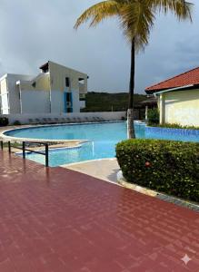 a swimming pool with a palm tree next to a building at Villa Marina by Otium in Fajardo