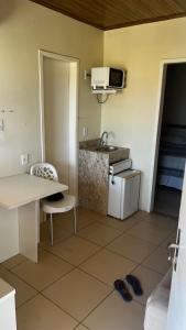 a small kitchen with a table and a sink at Condomínio Diver in Vera Cruz de Itaparica
