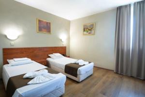 a hotel room with two beds and a window at Sveta Sofia Hotel in Sofia