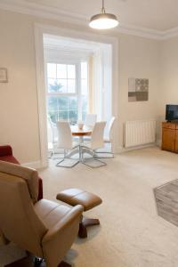 a living room with a table and white chairs at The Manor House in Peel