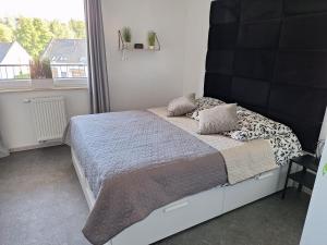 a bed in a bedroom with a large window at Apartament Śląskie Silesia in Zielona Góra