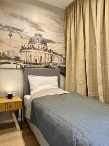 a bedroom with a bed and a painting of a building at Lichtdurchflutetes Design-Apartment U39-1 in Niederdorla