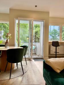 a living room with a table and chairs and windows at Lichtdurchflutetes Design-Apartment U39-1 in Niederdorla