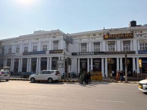 a large white building with cars parked in front of it at Hotel Bright in New Delhi