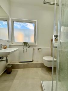 a bathroom with a toilet and a sink and a window at Lichtdurchflutetes Design-Apartment U39-1 in Niederdorla +17 photos