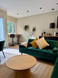 a living room with a green couch and a table at Lichtdurchflutetes Design-Apartment U39-1 in Niederdorla