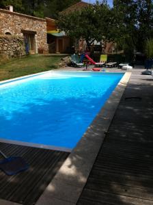 a swimming pool with blue water in a yard at La Parenthèse ardéchoise - Spa et billard - Se ressourcer entre ville et forêt in Privas
