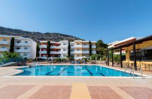 a swimming pool in front of some apartment buildings at Stella Hotel in Pefki