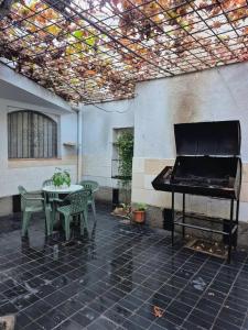 a piano sitting on a patio with a table and a table and a tableablish at Casa Lola María in Mendoza