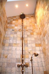 a shower in a bathroom with a tiled floor at La Parenthèse ardéchoise - Spa et billard - Se ressourcer entre ville et forêt in Privas +12 photos