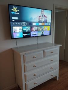 a flat screen tv on top of a dresser at Frisch saniertes Apartment am Falderapark in Neumünster