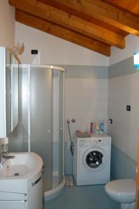 a bathroom with a washing machine and a sink at Casa Conchet in Polcenigo +25 photos
