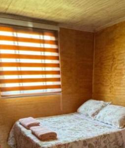 a bedroom with a bed with two towels on it at Cabaña Camino al Valle in La Marquesa